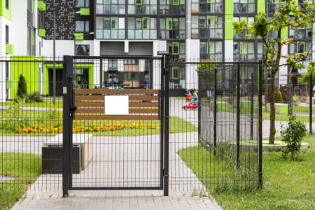 Gate with blank tablet of entrance in yard of apartment building